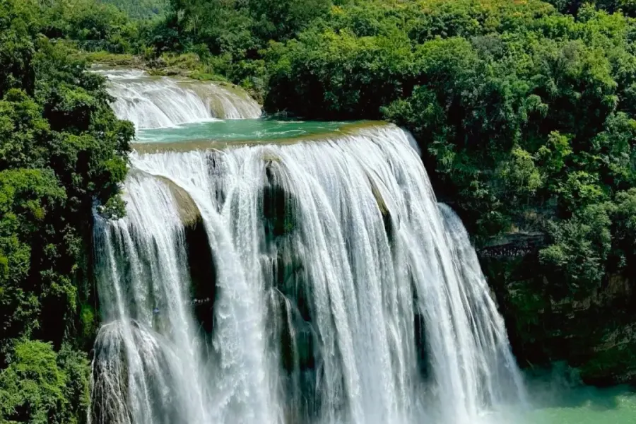 Magnificent grand karst waterfall with mist and rainbow, famous Water Curtain Cave