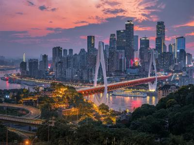 Chongqing city skyline at sunset with illuminated skyscrapers, bridges, and the Yangtze River urban landscape