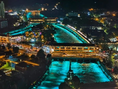Glowing turquoise Min River night scenery, Dujiangyan irrigation system illuminated at night, Sichuan China