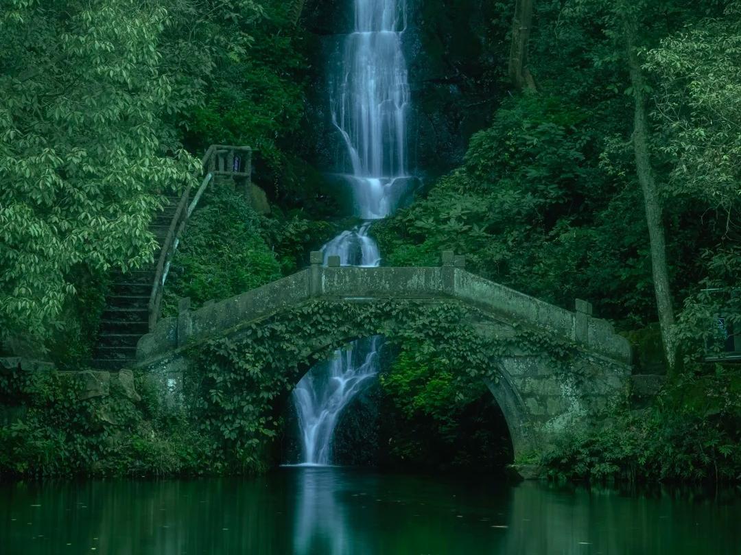 Scenic waterfall and old stone bridge in Nine?Creeks Hangzhou woodland