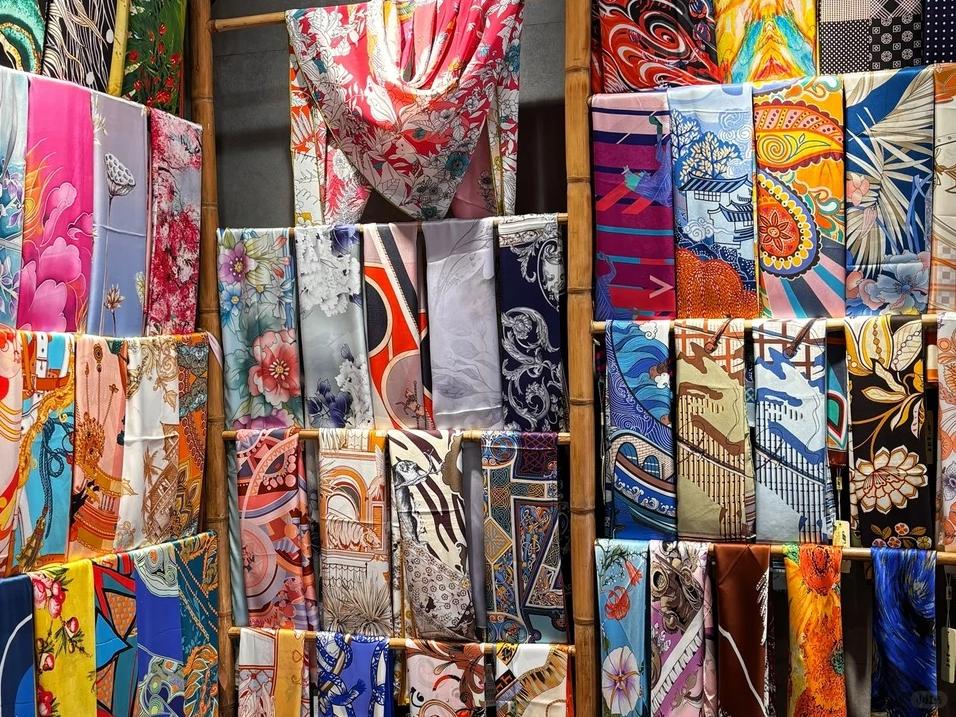 Colorful collection of silk scarves on display rack in Hangzhou silk market