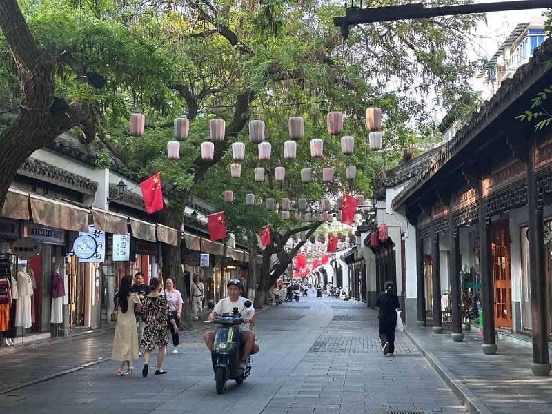 Bustling pedestrian street of Hangzhou Silk Market with traditional shops and lanterns