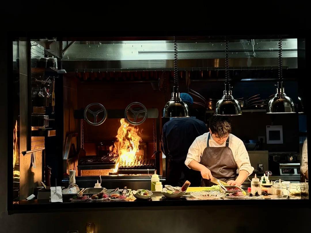 Chef working at open fire show kitchen