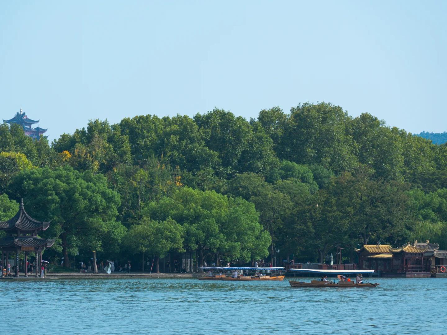 Sightseeing boats by West Lake historic shore pavilions