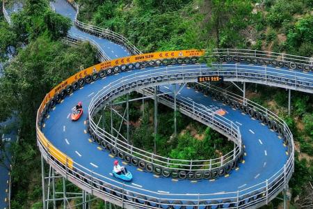Spiral mountain slide at Hangzhou OMG Heartbeat Paradise surrounded by lush forest scenery