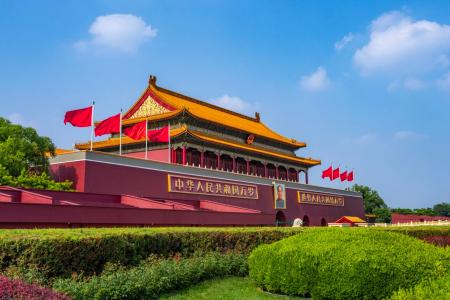 Tiananmen Square in Beijing with the iconic Tiananmen Gate, red flags, and traditional Chinese architecture