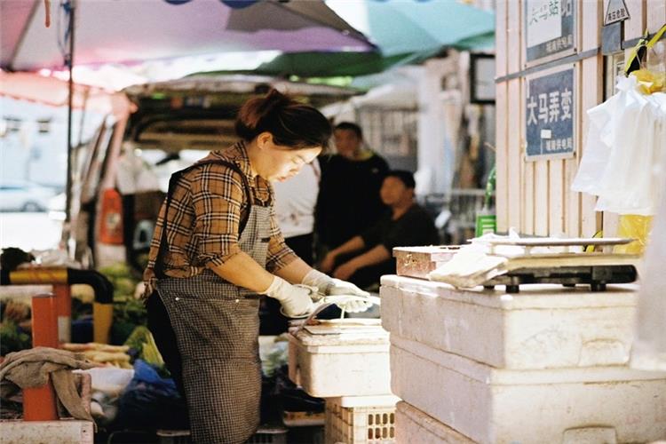 Vendor at Damalong Traditional Market Stall Local shopkeeper preparing fresh produce at bustling Damalong street market, Hangzhou daily life scene