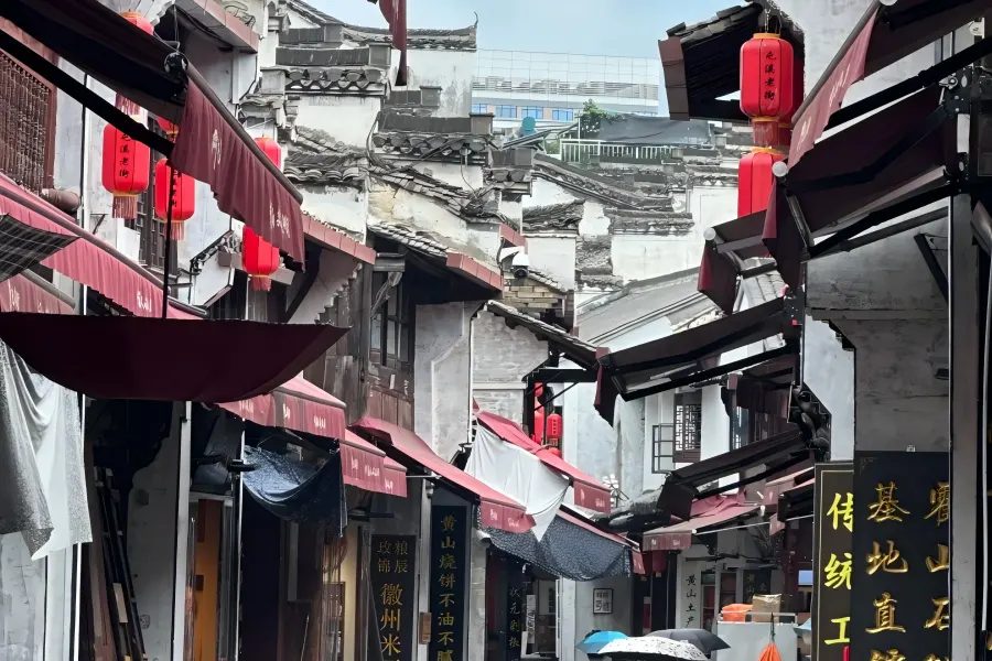 Tunxi Ancient Street in Huangshan showing well-preserved Song-Ming-Qing Hui-style ancient pedestrian street with carved wooden facades, red lanterns, time-honored tea and ink shops, known as the living Riverside Scene at Qingming Festival