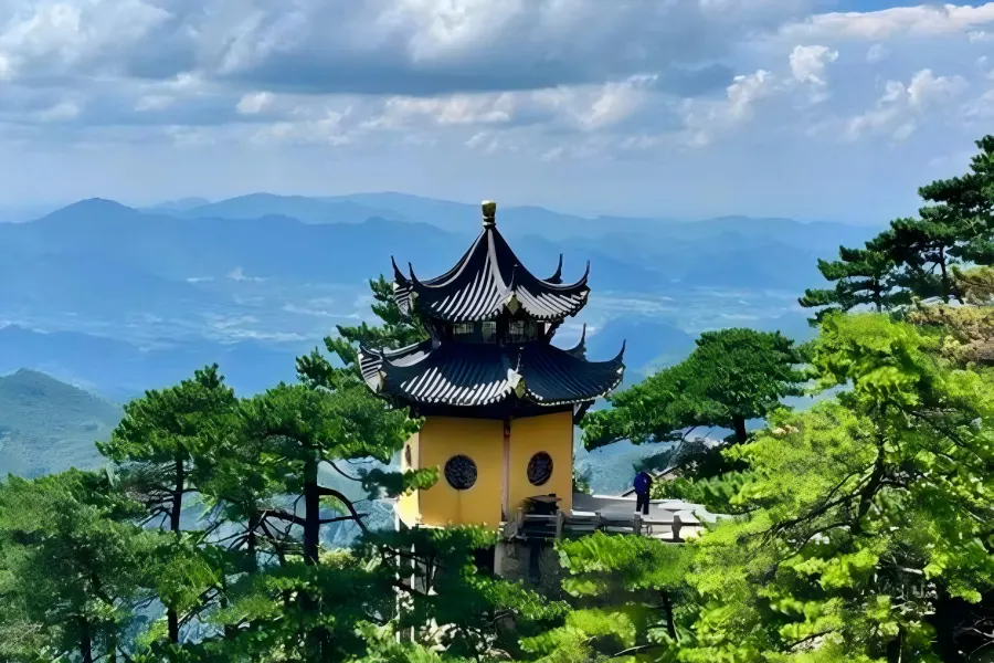 Mount Jiuhua in Anhui featuring misty Tiantai Peak summit, winding stone hiking trails, ancient pine trees and vast rolling cloud seas rolling over the 99 lotus-shaped mountain ridges