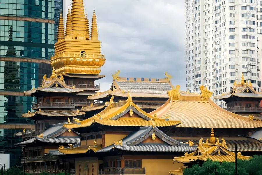 Jing'an Temple in Shanghai showcasing golden ancient Buddhist buildings standing amid modern downtown skyscrapers
