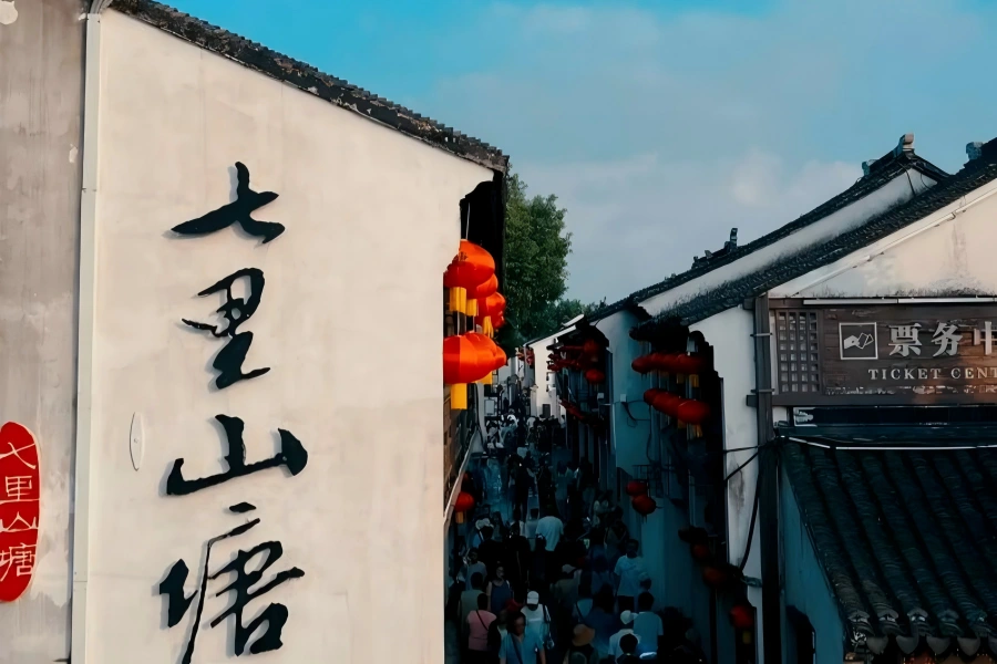 Jiangnan Water Town Shantang Canal View Shantang Street in Suzhou featuring white-wall black-tile waterside dwellings, stone arch bridges and wooden rowboats drifting along ancient canal