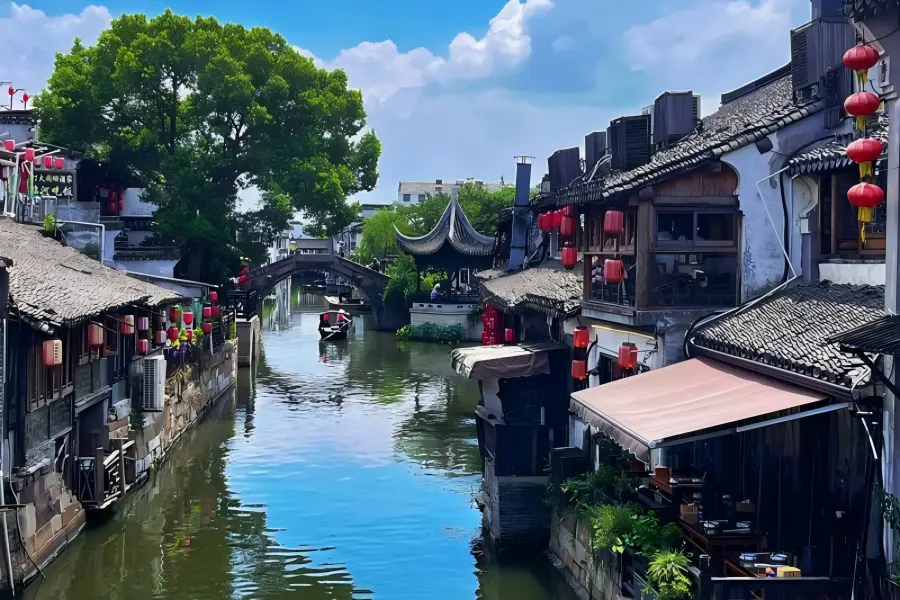 Xitang Ancient Town in Jiaxing featuring unique thousand-meter covered waterside corridors, labyrinthine narrow stone alleys and aged stone arch bridges lined with red lanterns along winding canals