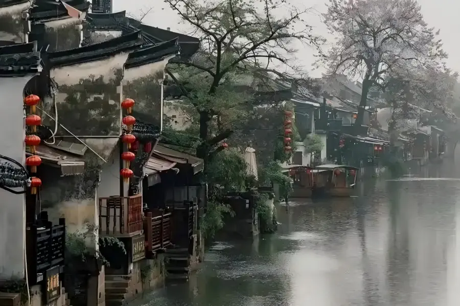 Xitang Ancient Town in Jiaxing boasts the world’s longest riverside covered misty rain corridor lined with wooden benches, alongside dense bluestone alleys and centuries-old stone arch bridges spanning winding waterways