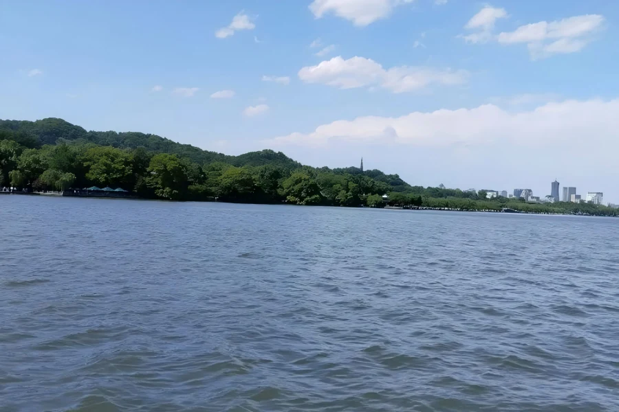 West Lake in Hangzhou showcasing serene lake views with antique sightseeing boats gliding across calm waters
