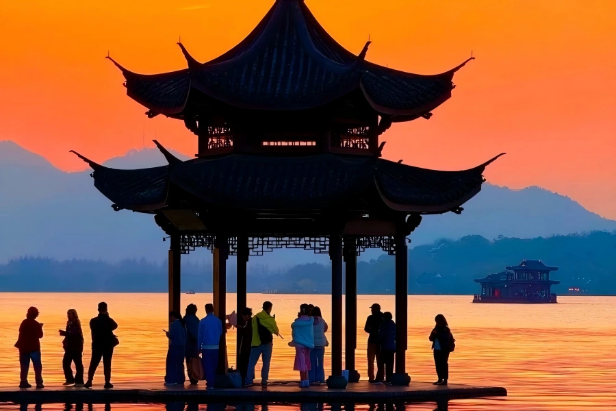 West Lake in Hangzhou showing gorgeous sunset glow spreading over lake surface and distant hills