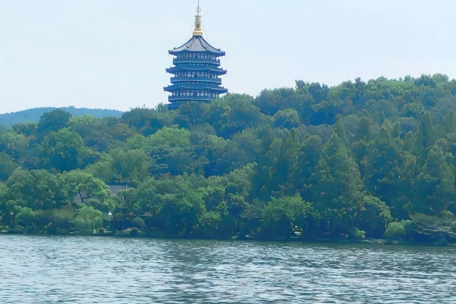 Picturesque scenery of West Lake featuring misty mountains, arched bridges and traditional waterside Chinese architecture