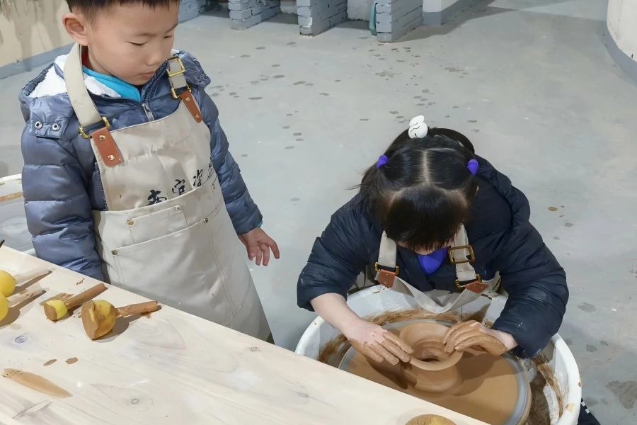 Children practicing clay throwing for pottery craft