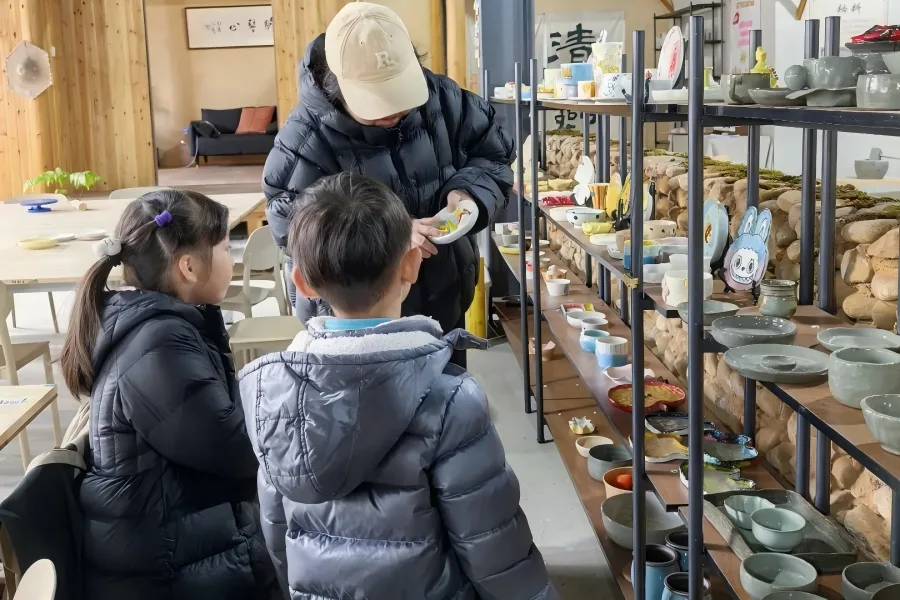 Instructor explaining porcelain exhibits to students at Southern Song Imperial Kiln Museum