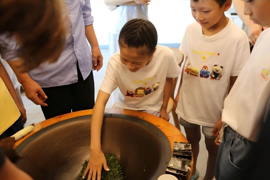 Student experiencing traditional hand?frying tea skill