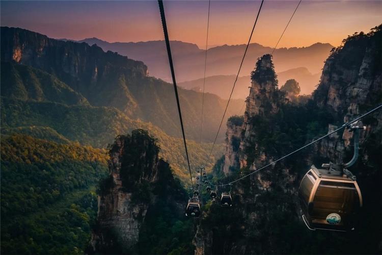 Zhangjiajie Cable Car Dusk Mountain View Cable cars crossing towering mountain pillars during sunset, Zhangjiajie Wulingyuan