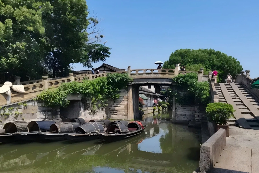 Fengyuan Double Bridge in Wuzhen showing divided ancient stone bridge spanning over calm water?town canal in East Zha
