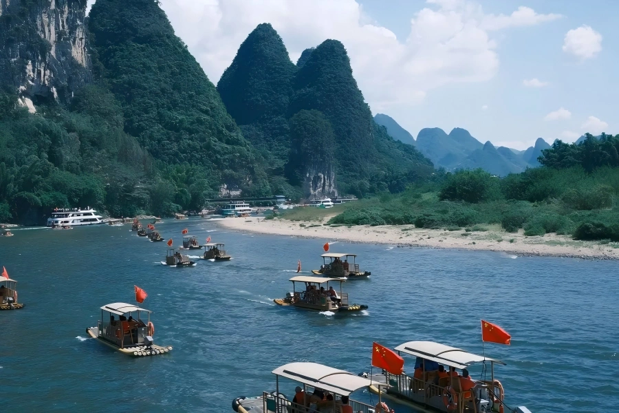 Li River Cruise in Guilin showing sightseeing boat sailing past spectacular karst limestone peaks and green?covered hills along the winding Li River