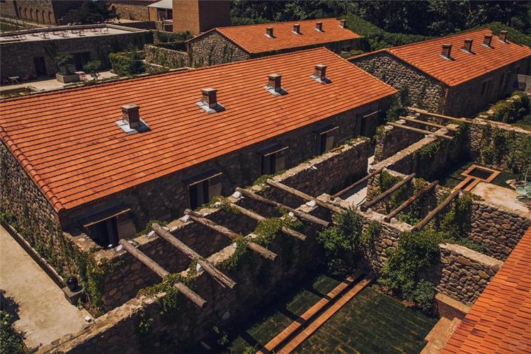Overhead shot of rustic stone winery buildings with red?tile roofs and vine?covered stone courtyards