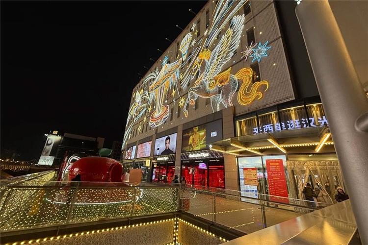 Colorful light art installation on facade of Hanguang Mall, bustling Xidan commercial district at night