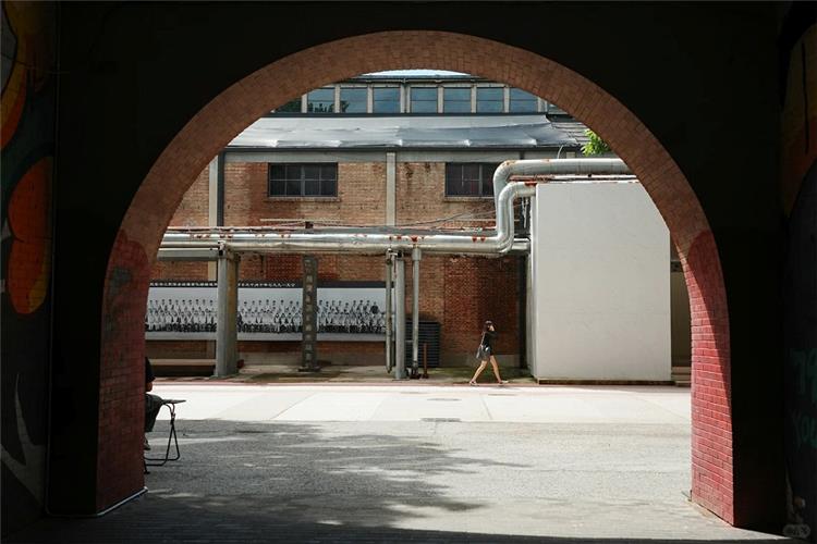 View through brick archway of vintage industrial brick factory buildings in 798 Art Zone, Beijing creative art district