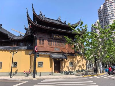 Street view of Jade Buddha Temple featuring traditional upturned eaves and yellow walls