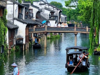Classic riverside scenery of Wuzhen East Gate, Jiangnan ancient town with stone bridge and wooden boat