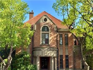 Vintage red brick villa of Suzhou No.1 Silk Factory surrounded by green trees
