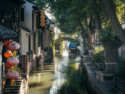 View of Zhouzhuang ancient water town, canal lined with old houses, red lanterns, stone arch bridge and covered boat