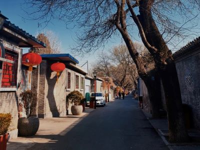 Quiet street view of Nanluoguxiang Hutong with traditional grey tile houses and red Chinese lanterns