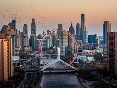 Panoramic view of Tianjin Eye Ferris wheel across Hai River surrounded by modern high-rise buildings