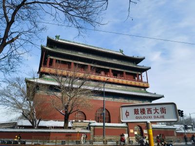 Traditional ancient Bell Tower of Beijing beside Gulou West Street sign under clear blue sky