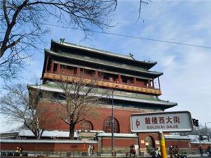 Traditional ancient Bell Tower of Beijing beside Gulou West Street sign under clear blue sky