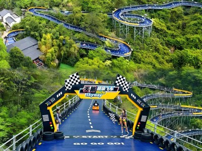 Winding elevated mountain go-kart track surrounded by lush green woods at OMG Park, popular outdoor amusement attraction in Hangzhou
