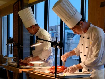 The chef in a Beijing restaurant cuts Beijing roast duck in front of customers
