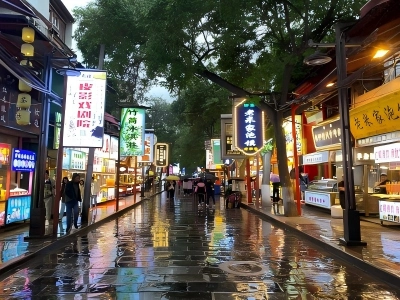 Wet stone road with glowing food signs on Muslim Quarter Xi'an