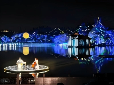 Live performers on floating stage at Impression West Lake night performance with lake light scenery