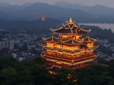 Lit ancient Chenghuang Pavilion with distant Leifeng Pagoda and West Lake at dusk