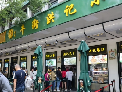 Busy food shop on Beijing Niujie Muslim food street with queuing visitors
