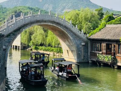 Ancient Stone Arch Bridge And Wooden Tour Boats On River At Gubei Water Town Jiangnan Style Waterside Town View