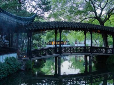 The lush green scenery of the Suzhou Humble Administrator's Garden corridor bridge