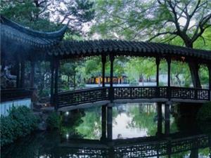 The lush green scenery of the Suzhou Humble Administrator's Garden corridor bridge