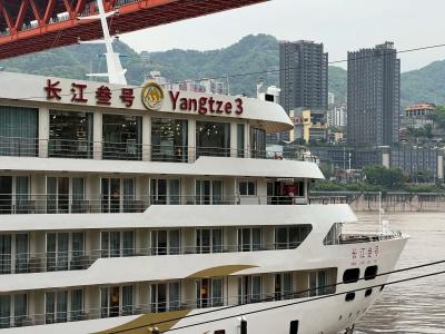 Yangtze 3 cruise ship sailing on the Yangtze River with Chongqing city skyline and mountain views in the background