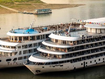 Two Luxury Yangtze River Cruise Ships Docked Side By Side On Calm Riverside Golden Hour Waters