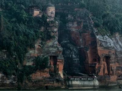 Leshan Giant Buddha carved into the red sandstone cliff overlooking the Min River in Sichuan