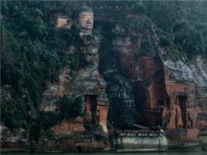 Leshan Giant Buddha carved into the red sandstone cliff overlooking the Min River in Sichuan